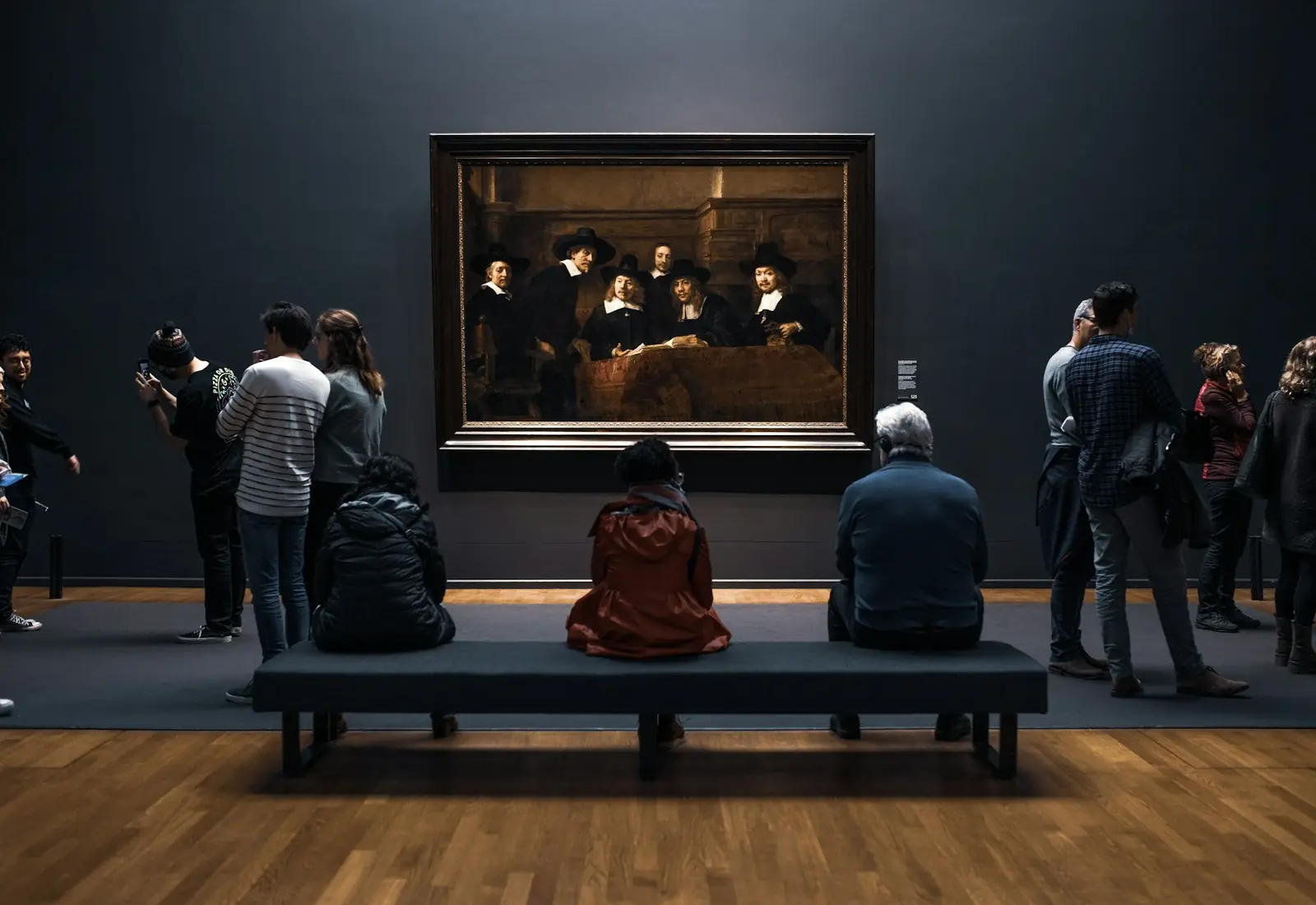 Bezoekers kijken samen naar een schilderij in een museumzaal